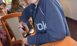 Dávid zapisuje odpovede celej skupiny. Hudobný kvíz im ide od ruky.